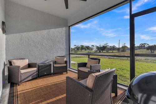 a room with a patio with chairs and a large window at Three-Bedroom House in Lehigh Acres