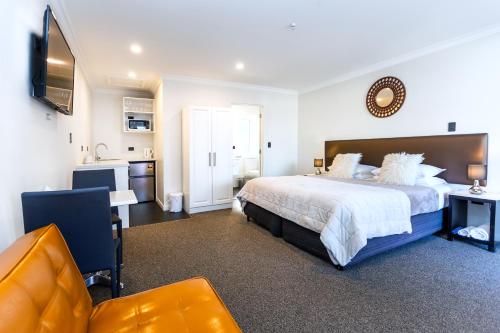 a large bedroom with a large bed and a desk at Superior Dunedin Apartments in Dunedin