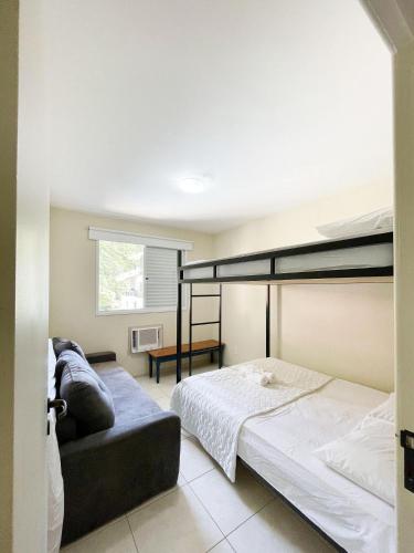 a bedroom with two bunk beds and a couch at Residencial Porto da Brava - NDI001 in Florianópolis