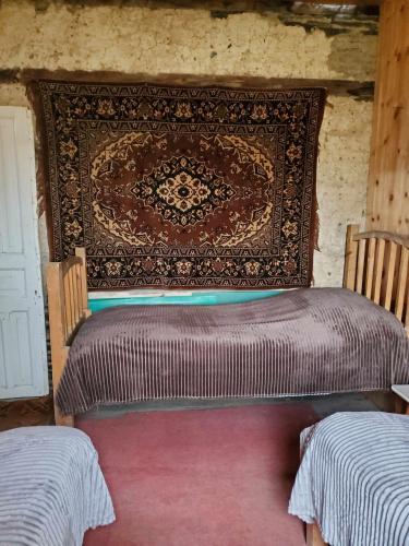 a bed in a room with a tapestry on the wall at paradise of tusheti in Omalo