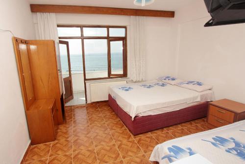 a bedroom with two beds and a view of the ocean at PINAR OTEL in Amasra