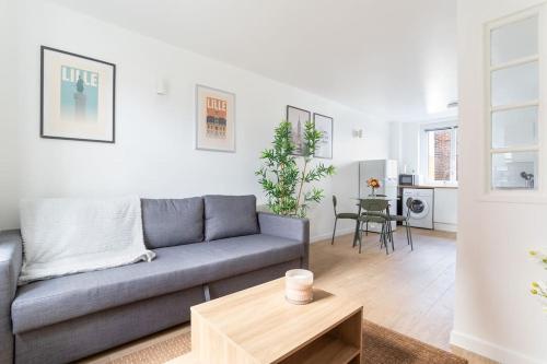 un salon avec un canapé et une table dans l'établissement Lille - Bel Appartement Cosy et Lumineux, à Lille