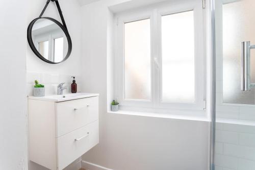 a white bathroom with a sink and a mirror at Lille - Bel Appartement Cosy et Lumineux in Lille