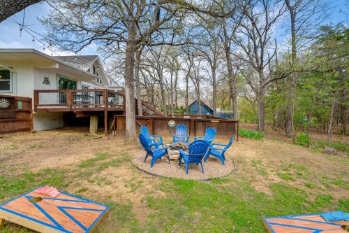 a patio with blue chairs and a table in a yard at Versatile Home with Deck and Grill, 1 Mi to Lake! in Pottsboro