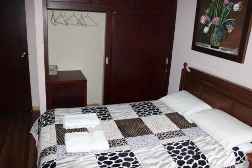 a bedroom with a black and white quilt on a bed at Casa de Tulia in Quito
