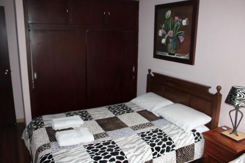a bedroom with a bed with a black and white quilt at Casa de Tulia in Quito