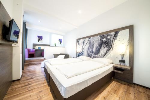 a bedroom with two beds and a flat screen tv at ArtHotel City in Nürnberg