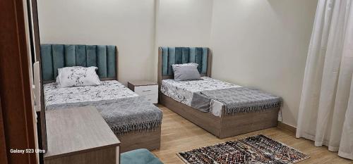 a room with two beds and a table at VIP Nile Tower in Cairo