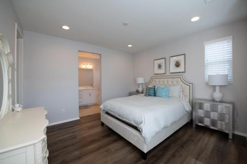 um quarto branco com uma cama com almofadas azuis em Luxury Villa in Irvine Great Park 3 Bedrm 2 Bath em Irvine