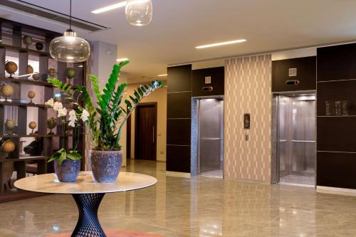 a lobby with a table with a plant on it at Doubletree by Hilton Milan Malpensa Solbiate Olona in Solbiate Olona