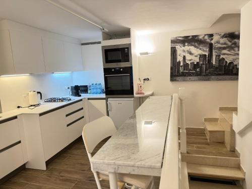 a white kitchen with a table and a microwave at Apartment Wagner in Milan