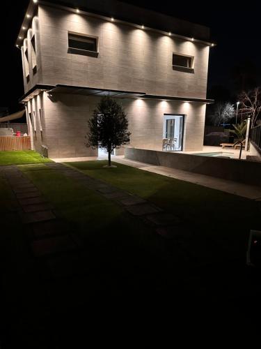 a house with lights on the side of it at night at Shome in Vilanova i la Geltrú