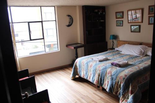 a bedroom with a bed and a large window at Casa de Tulia in Quito