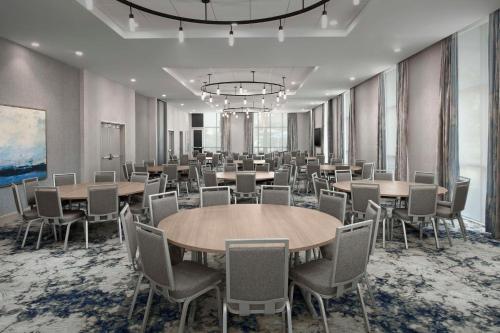 a conference room with tables and chairs and a chandelier at Hilton Garden Inn Pensacola Downtown in Pensacola