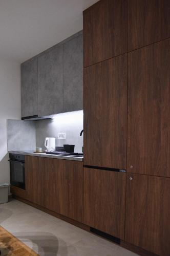 a kitchen with wooden cabinets and a stove at CROWN apartment 3 in Subotica