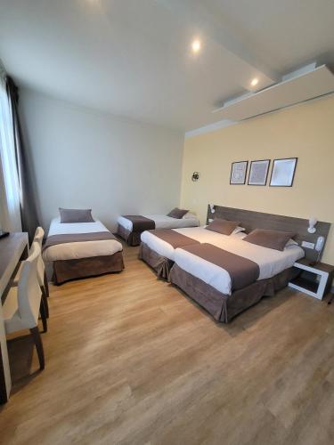 three beds in a room with wooden floors at KYRIAD ORANGE Centre Ville - HOTEL & RESTAURANT & BAR - La Galerie d'Art des Princes - Provence Alpes Côte d'Azur - France - Proche A7-A9 - exit21- Châteauneuf-du-Pape Avignon Bollene Nimes - 24h-24h in Orange