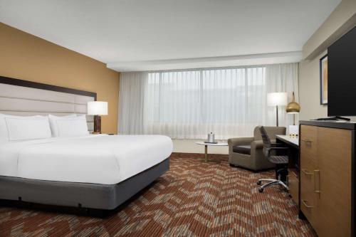 Habitación de hotel con cama grande y escritorio. en Doubletree By Hilton Greensboro Airport en Greensboro