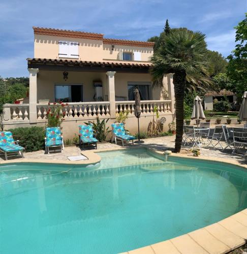 a swimming pool in front of a house at Deux chambres dans villa proche de la plage in Sète