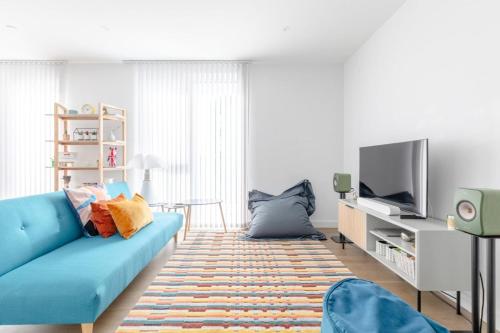 ロンドンにあるStylish 2BD Oasis wBalcony South East London!のリビングルーム(青いソファ、テレビ付)