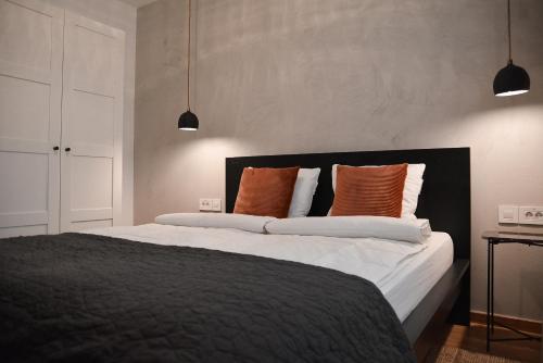 a bedroom with a large bed with orange and white pillows at CROWN apartment 3 in Subotica