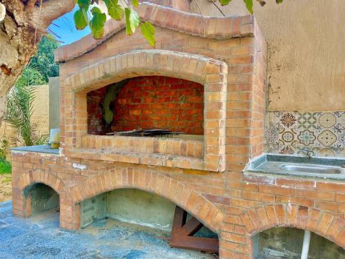 un forno per pizza in mattoni seduto su un patio di 4-BRS Entire FarmHouse in Ismailia lGreen Paradise a Ismailia