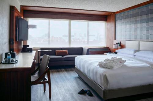 Habitación de hotel con cama y sofá en Detroit Marriott Southfield, en Southfield