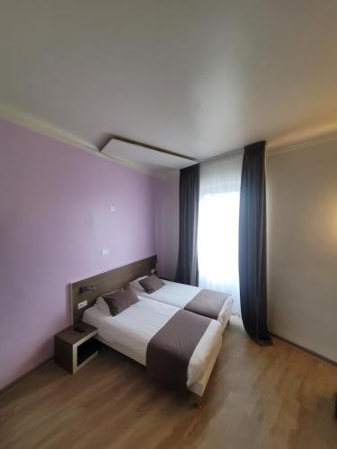 a bedroom with a large bed and a window at KYRIAD ORANGE Centre Ville - HOTEL & RESTAURANT & BAR - La Galerie d'Art des Princes - Provence Alpes Côte d'Azur - France - Proche A7-A9 - exit21- Châteauneuf-du-Pape Avignon Bollene Nimes - 24h-24h in Orange