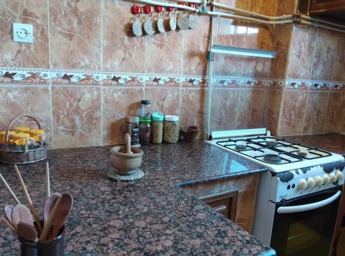 uma cozinha com um fogão e uma bancada em Iwaren appartement em Orão