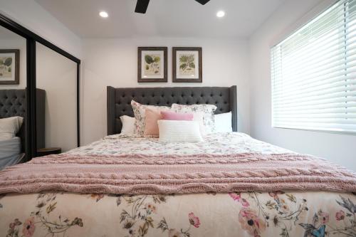 a bedroom with a large bed with pink blankets and pillows at Destination #50 in Placentia