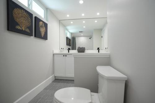 a white bathroom with a toilet and a sink at Destination #50 in Placentia