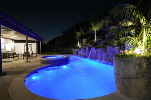a swimming pool with blue lighting at night at Destination #50 in Placentia