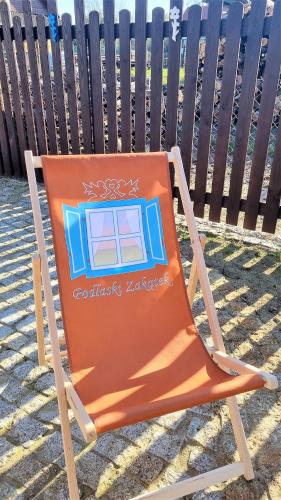 an orange chair sitting in front of a fence at Podlaski Zakątek in Bereżyszcze