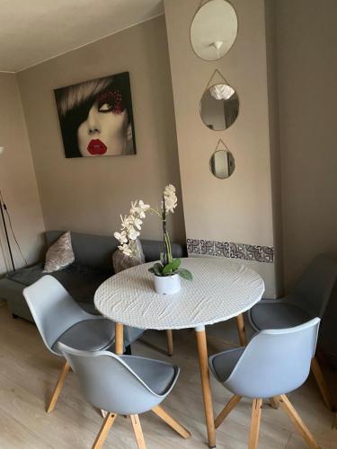 une salle à manger avec une table et quatre chaises dans l'établissement Cosy appartement 2P, 10 mn Paris Opéra, à Aubervilliers
