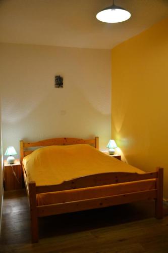 - une chambre avec un lit dans une pièce jaune dans l'établissement Résidence Les Bergers - 2 pièces cabine 4 personnes exposé Nord-Ouest MAE-8954, à Valloire