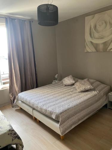 une chambre avec un lit et un tableau au mur dans l'établissement Cosy appartement 2P, 10 mn Paris Opéra, à Aubervilliers