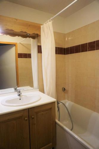 une salle de bain avec un lavabo, une baignoire et un miroir dans l'établissement Résidence Cristallines - 3 Pièces 6 Personnes MAE-2454, à Orcières