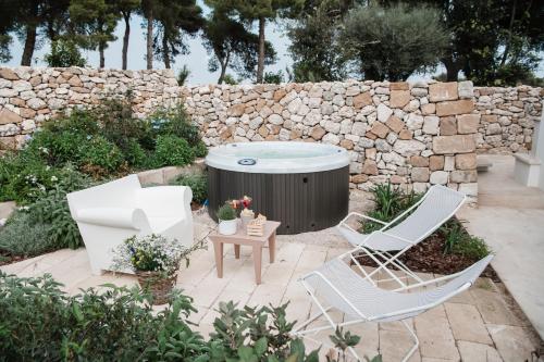 2 stoelen en een hot tub in de tuin bij La Vacia Boutique Country Resort in Pulsano