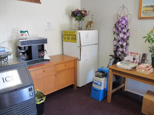 een keuken met een koelkast en een tafel met bloemen bij Economy Inn Ontario in Ontario