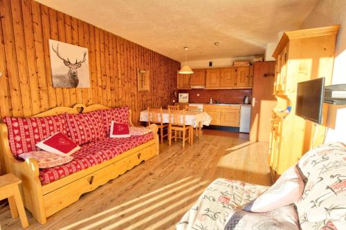 un salon avec un canapé et une cuisine avec une table dans l'établissement Résidence Les Alpages - Appartement Sud avec vues montagnes, skis aux pieds MAE-2664, à Notre-Dame-de-Bellecombe