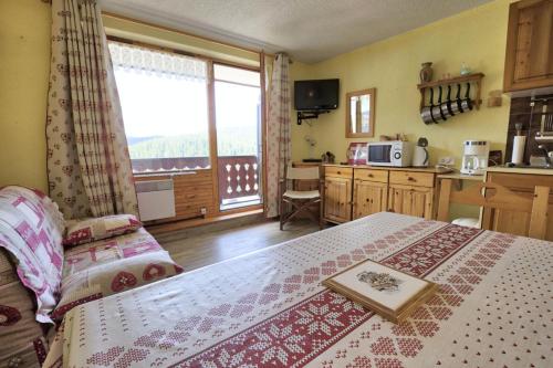 Cet appartement comprend une chambre avec un lit et une cuisine avec une fenêtre. dans l'établissement Résidence Les Crocus - Studio avec une vue exceptionnelle MAE-2704, à Notre-Dame-de-Bellecombe