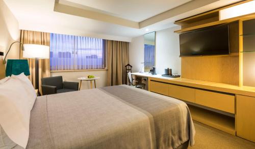 a hotel room with a bed and a flat screen tv at Galeria Plaza Reforma in Mexico City