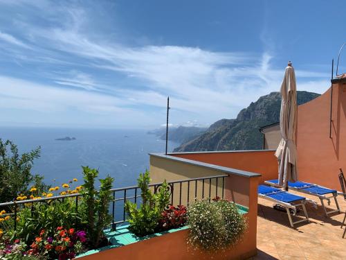 balcón con sombrilla y vistas al océano en Anna Apartment en Positano
