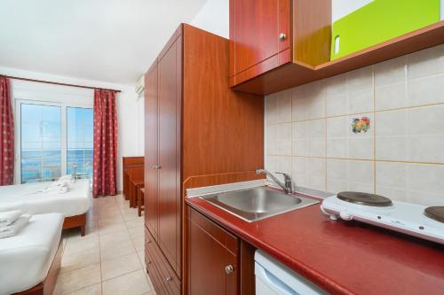 uma pequena cozinha com um lavatório e uma cama em Hotel Smaragdi em Chrysi Ammoudia