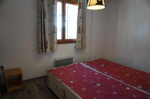 - une chambre avec un lit rouge et une fenêtre dans l'établissement Résidence Terrasses De La Bergerie - 3 pièces 6 personnes MAE-8934, à Orcières