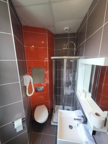 a bathroom with a white toilet and a sink at KYRIAD ORANGE Centre Ville - HOTEL & RESTAURANT & BAR - La Galerie d'Art des Princes - Provence Alpes Côte d'Azur - France - Proche A7-A9 - exit21- Châteauneuf-du-Pape Avignon Bollene Nimes - 24h-24h in Orange
