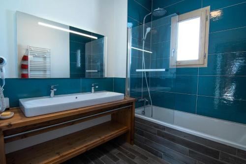 a blue bathroom with a sink and a shower at Chalet KopÉrek - Chalets pour 12 Personnes 514 in Valloire