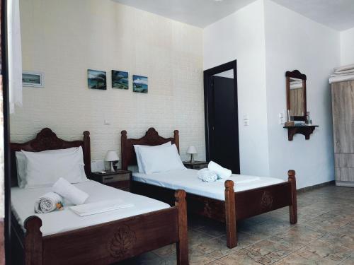 2 camas individuales en una habitación con espejo en Orantes Maris Luxury en Katapola
