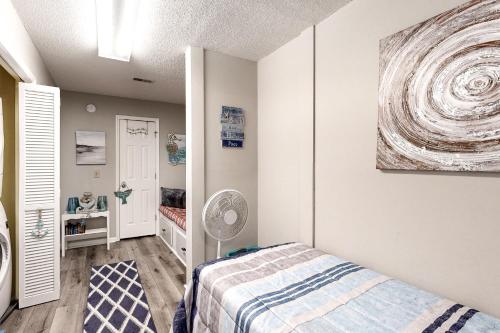 a small bedroom with a bed and a fan at Waccamaw Condo - Unit 6 in Myrtle Beach