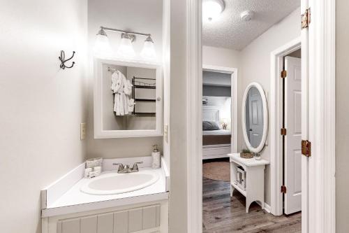 a white bathroom with a sink and a mirror at Waccamaw Condo - Unit 6 in Myrtle Beach