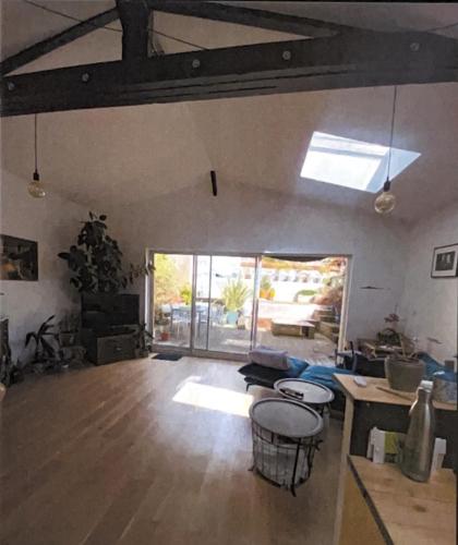 uma sala de estar com piso em madeira e uma grande janela em Le cabanon planqué em Bordeaux